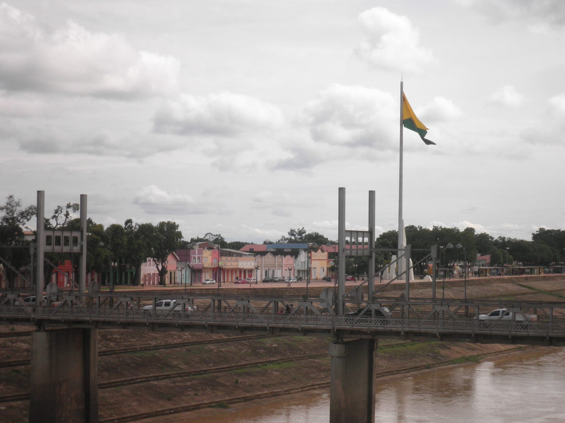 Calçadão da Gameleira à beira do Rio Acre, com a bandeira do estado e a estrutura da passarela ao fundo