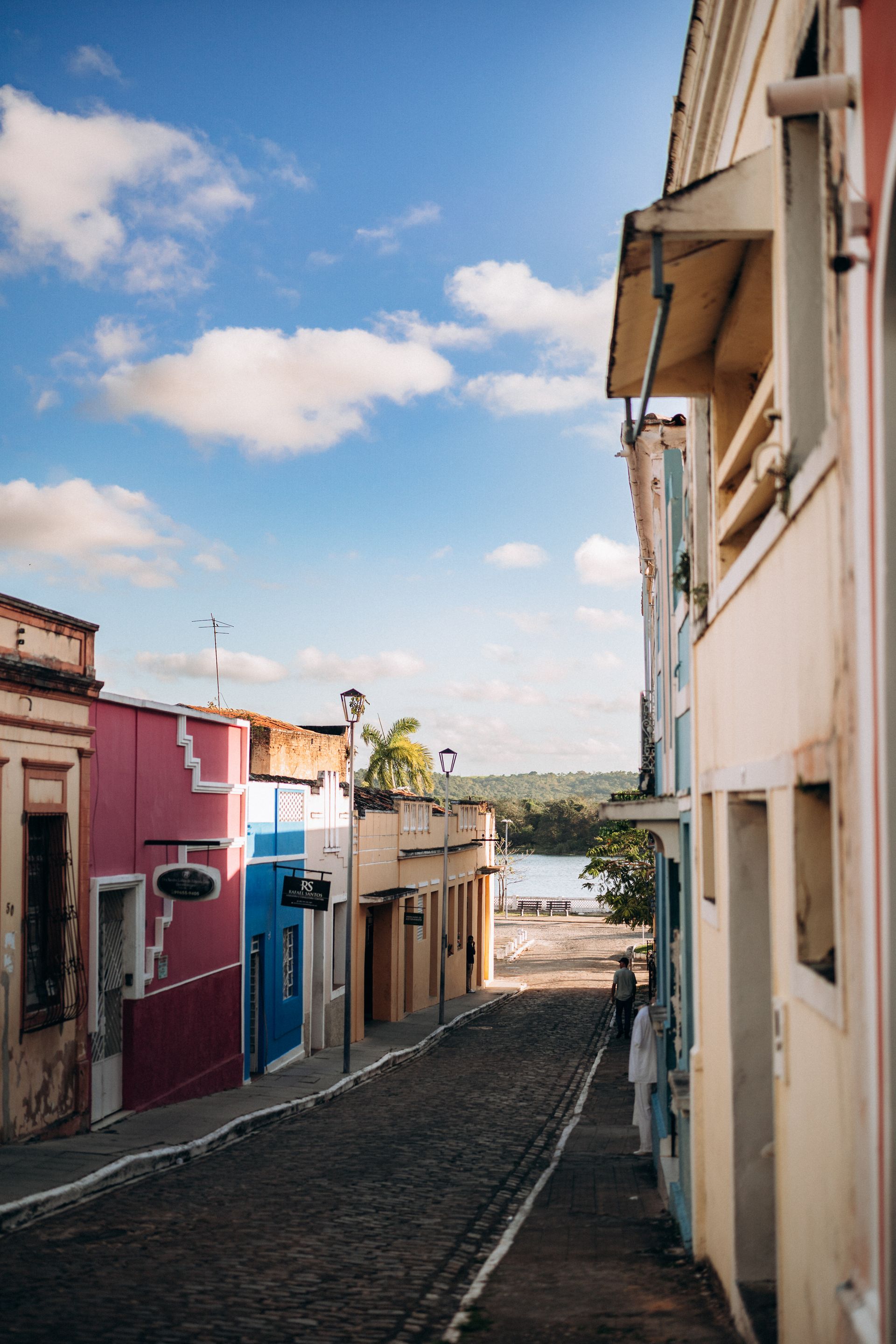 Rua de paralelepípedos com casario colorido no centro histórico de Penedo