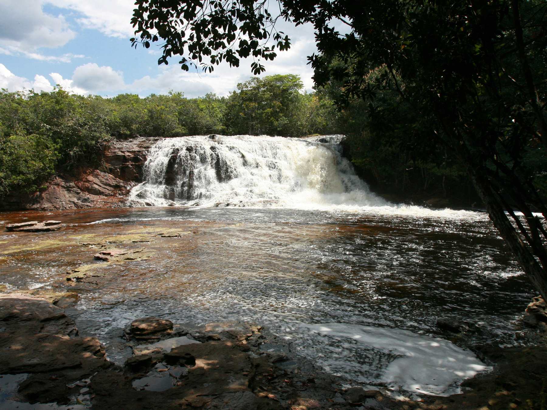 Cachoeira de Iracema em Presidente Figueiredo, com a água branca caindo em cortina larga sobre a rocha e a mata fechada nas duas margens