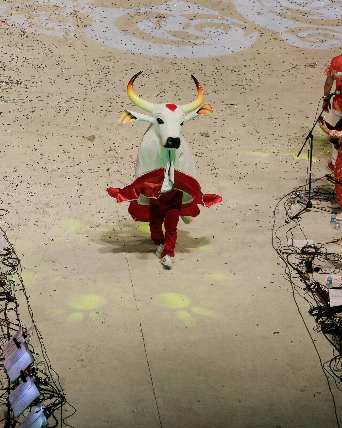 Apresentação no Bumbódromo de Parintins, com a figura do boi dançando no centro da arena e a galera e a batucada nas laterais.