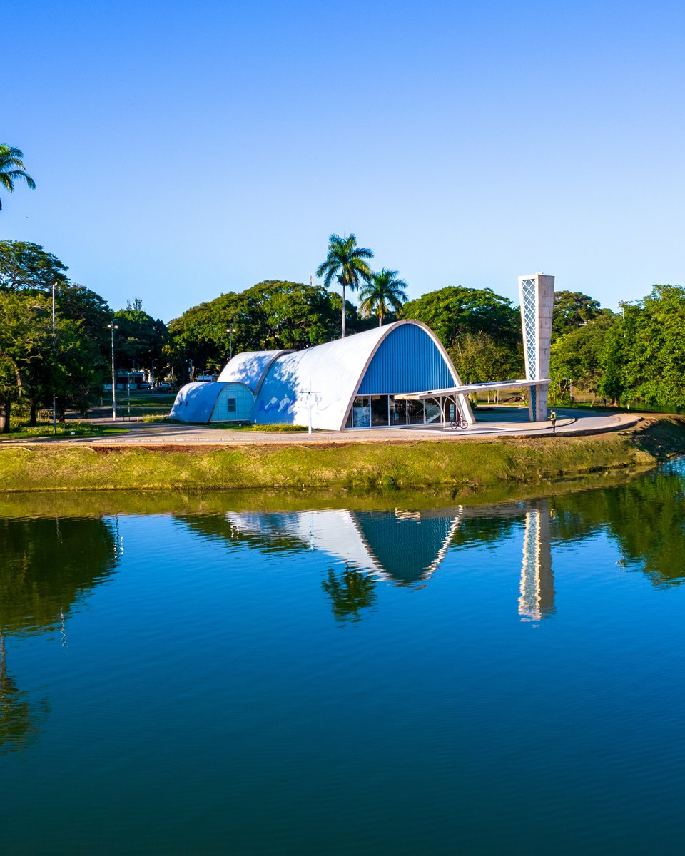 Igreja de São Francisco de Assis, a igrejinha da Pampulha projetada por Oscar Niemeyer, refletida na Lagoa da Pampulha num dia de céu azul, em Belo Horizonte.