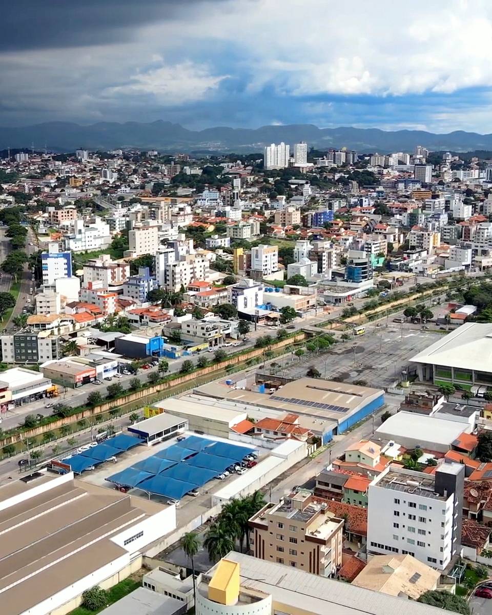 Vista do alto de Betim, com prédios, casas e uma avenida larga.