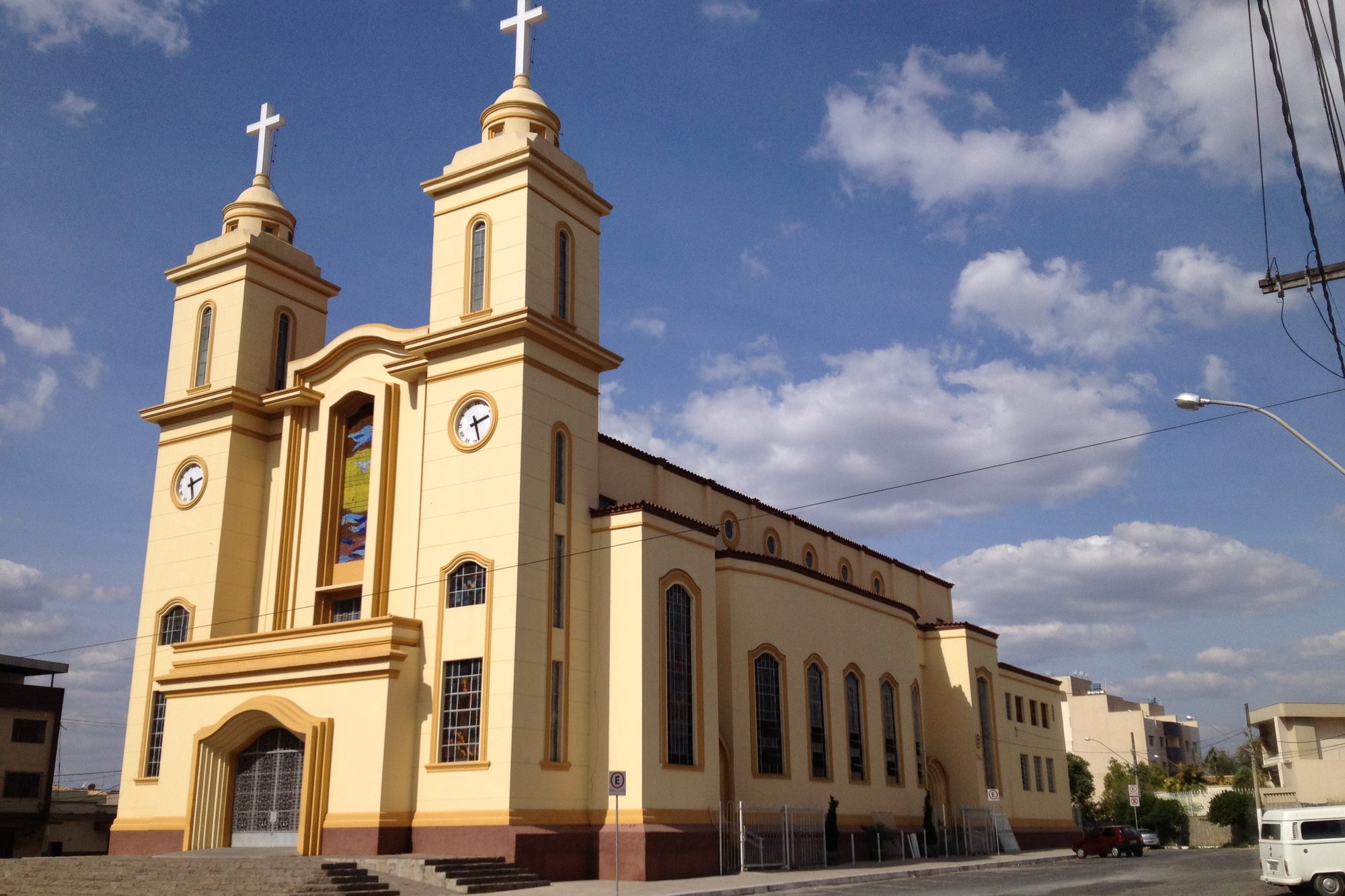 Catedral do Divino Espírito Santo, amarela e branca, com as duas torres de relógio.