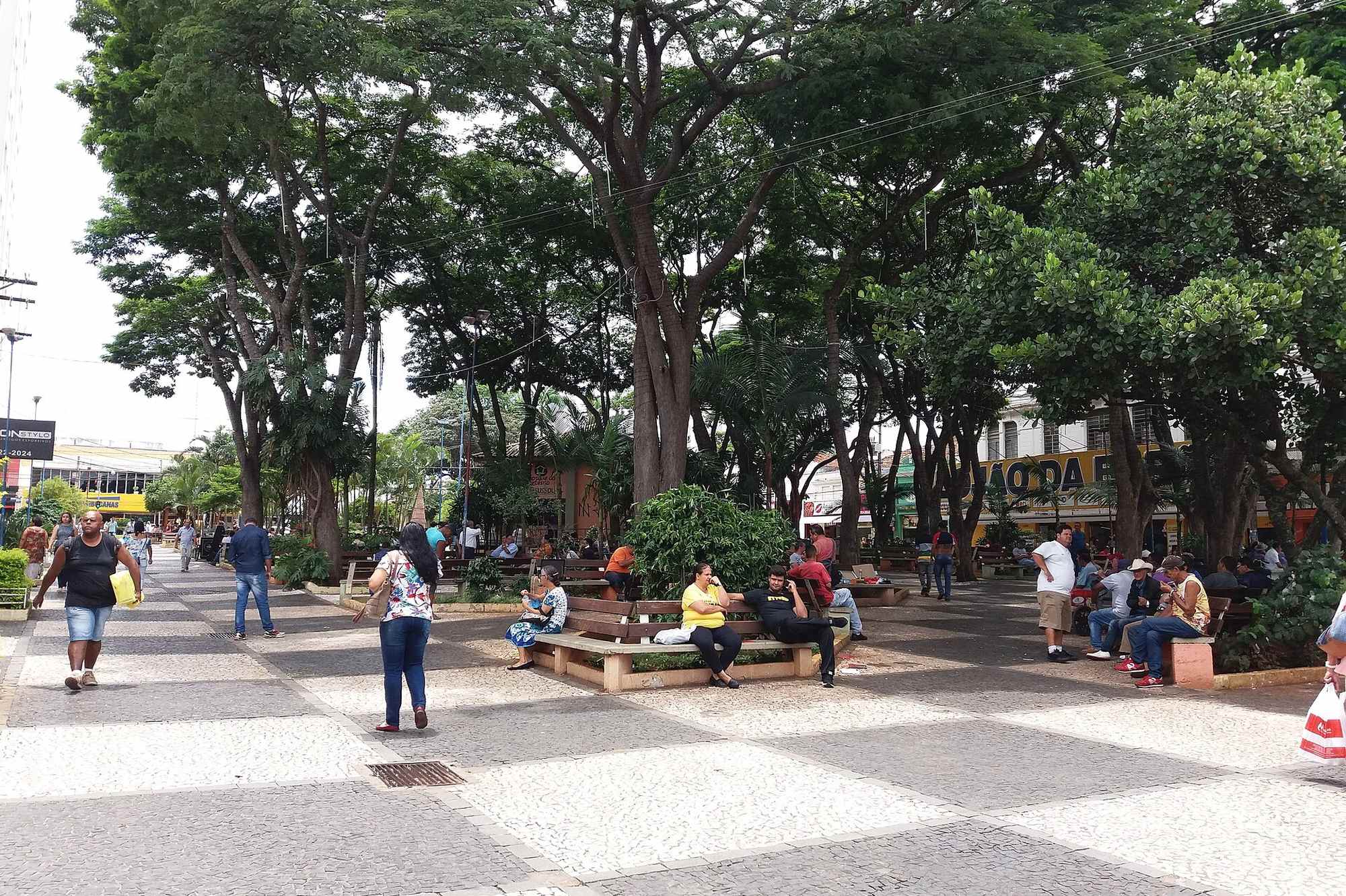 Praça Barão da Franca, no Centro, com gente nos bancos à sombra das árvores.
