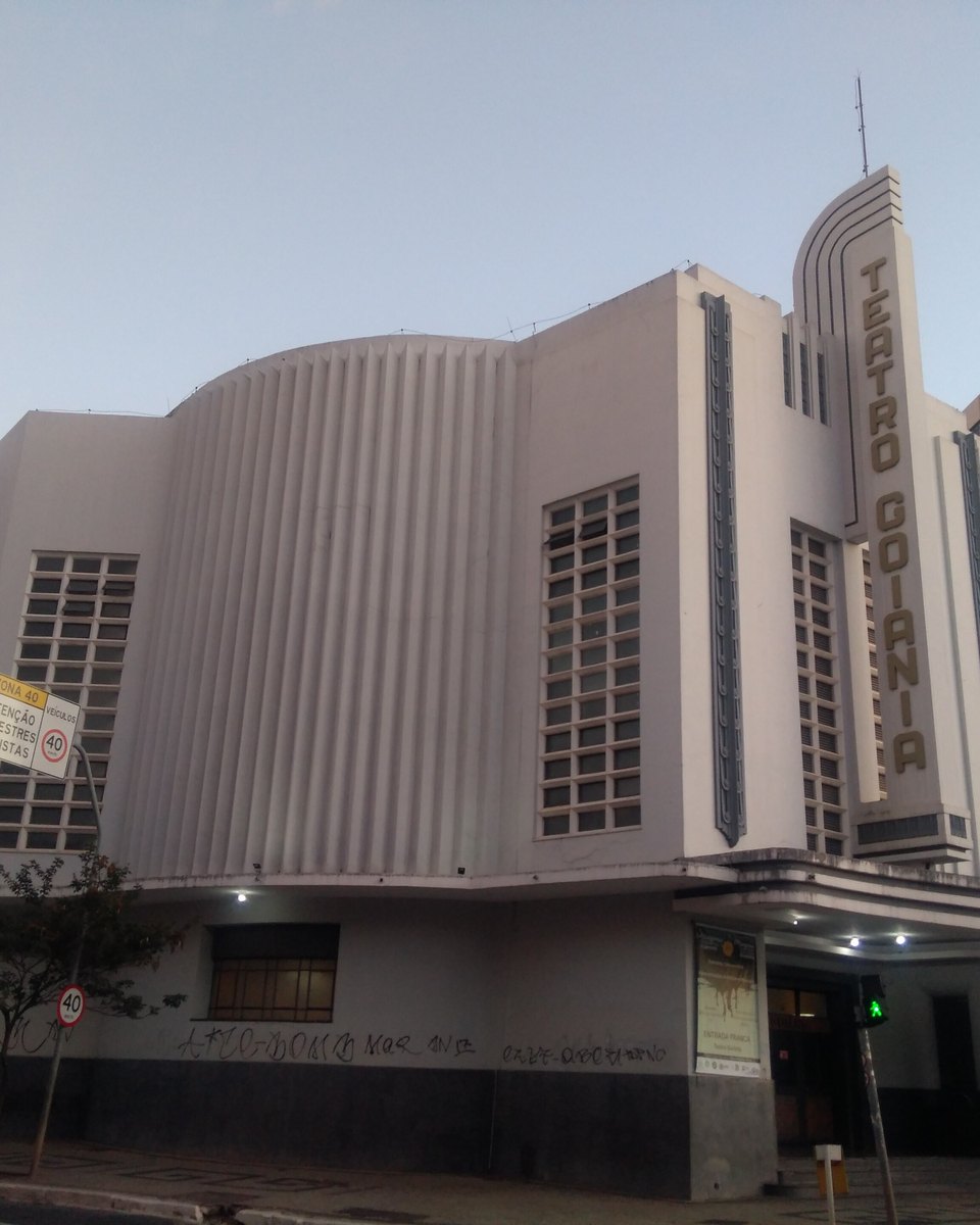 Fachada art déco do Teatro Goiânia, branca e curva, com o letreiro vertical na torre da esquina.