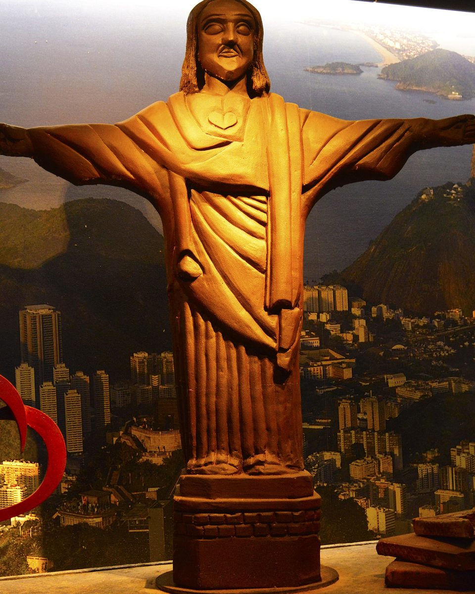 Estátua do Cristo Redentor feita de chocolate diante de um painel com a paisagem do Rio de Janeiro, no Mundo do Chocolate, em Gramado.