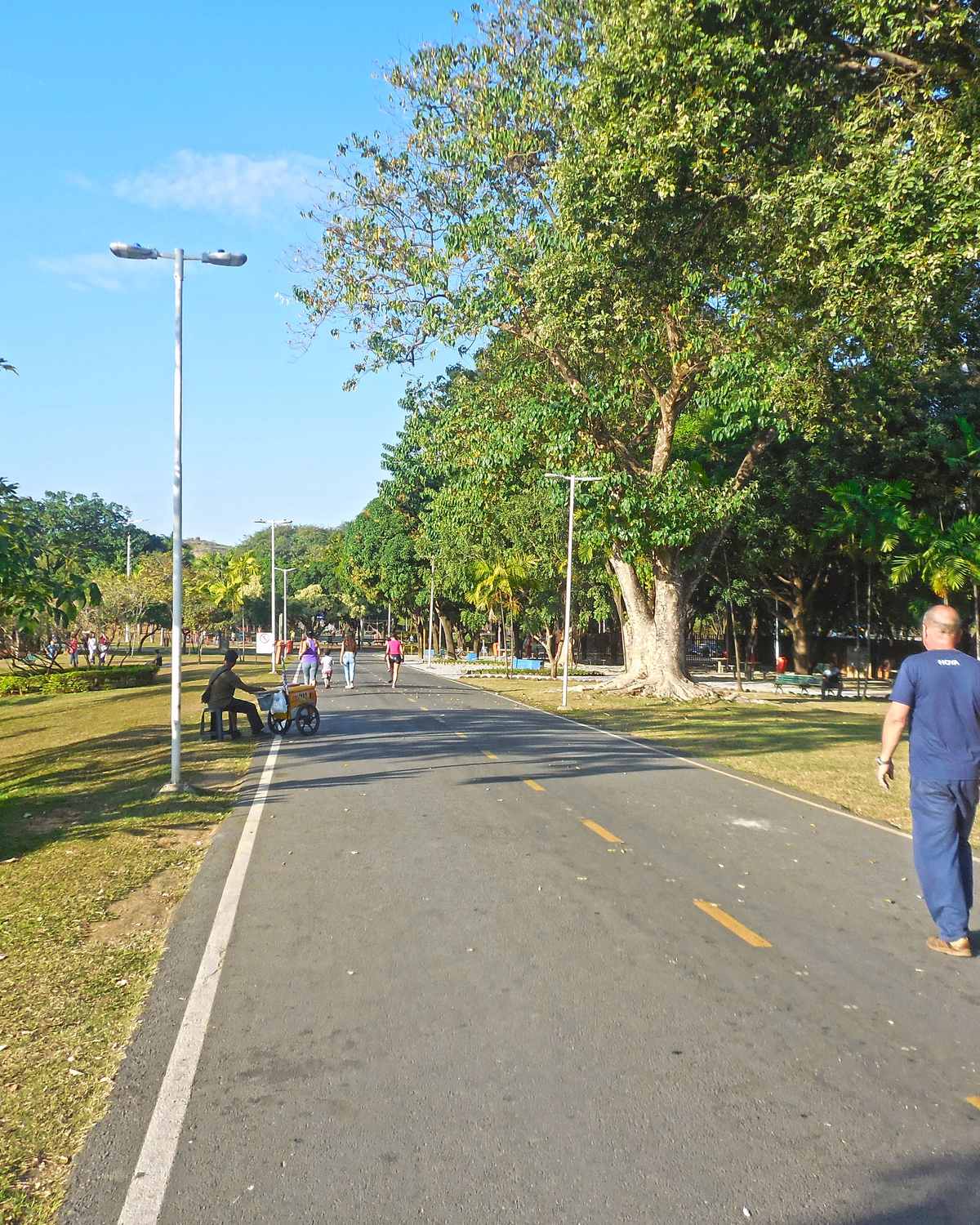 Pessoas caminhando na pista do Parque Ipanema, em Ipatinga, num dia de sol.