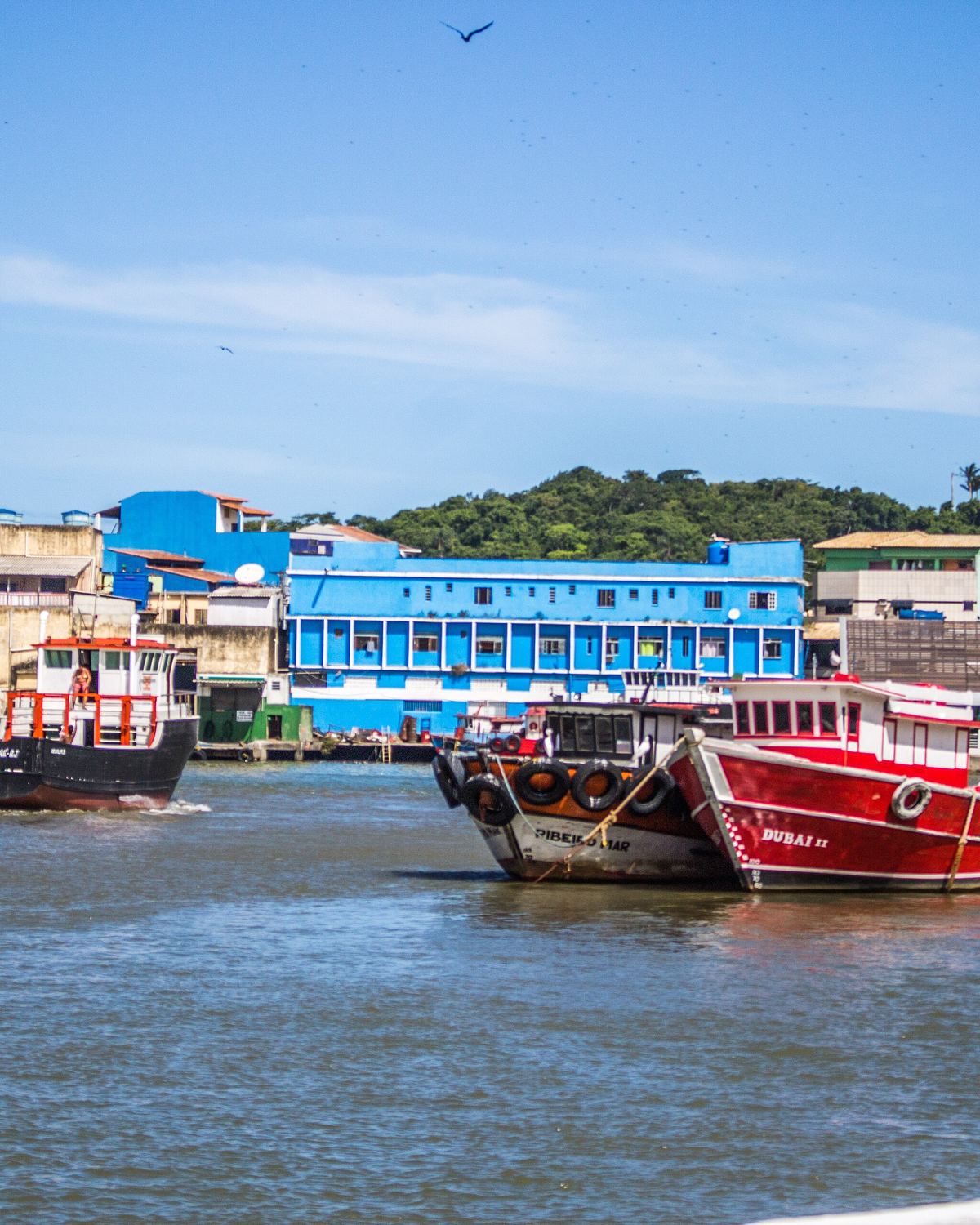 Barcos de pesca vermelhos ancorados na foz do Rio Macaé.