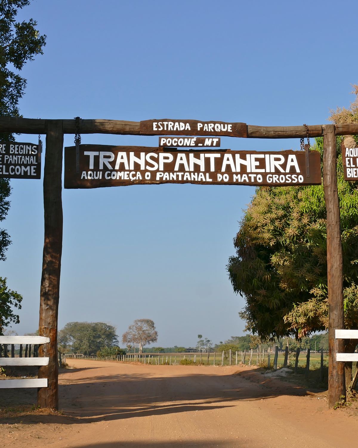 Portal de madeira da Rodovia Transpantaneira, em Poconé, sobre a estrada de terra vermelha que entra no Pantanal mato-grossense.