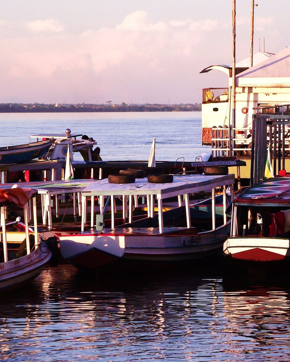 Orla de Marabá no rio Tocantins ao entardecer, com barcos de passageiros coloridos atracados no flutuante.