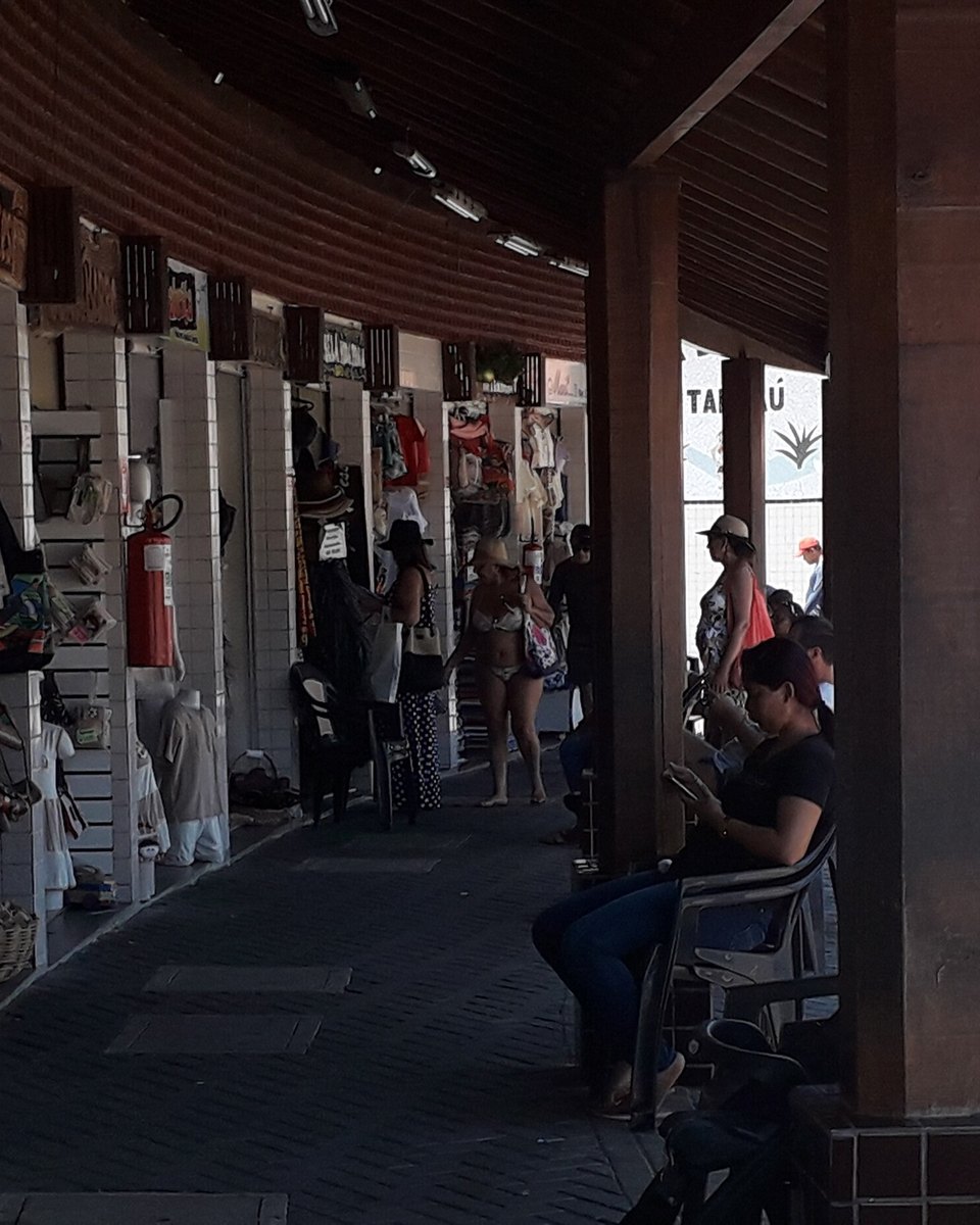 Comerciante sentada mexendo no celular na sua banca da Feirinha de Artesanato de Tambaú, em João Pessoa