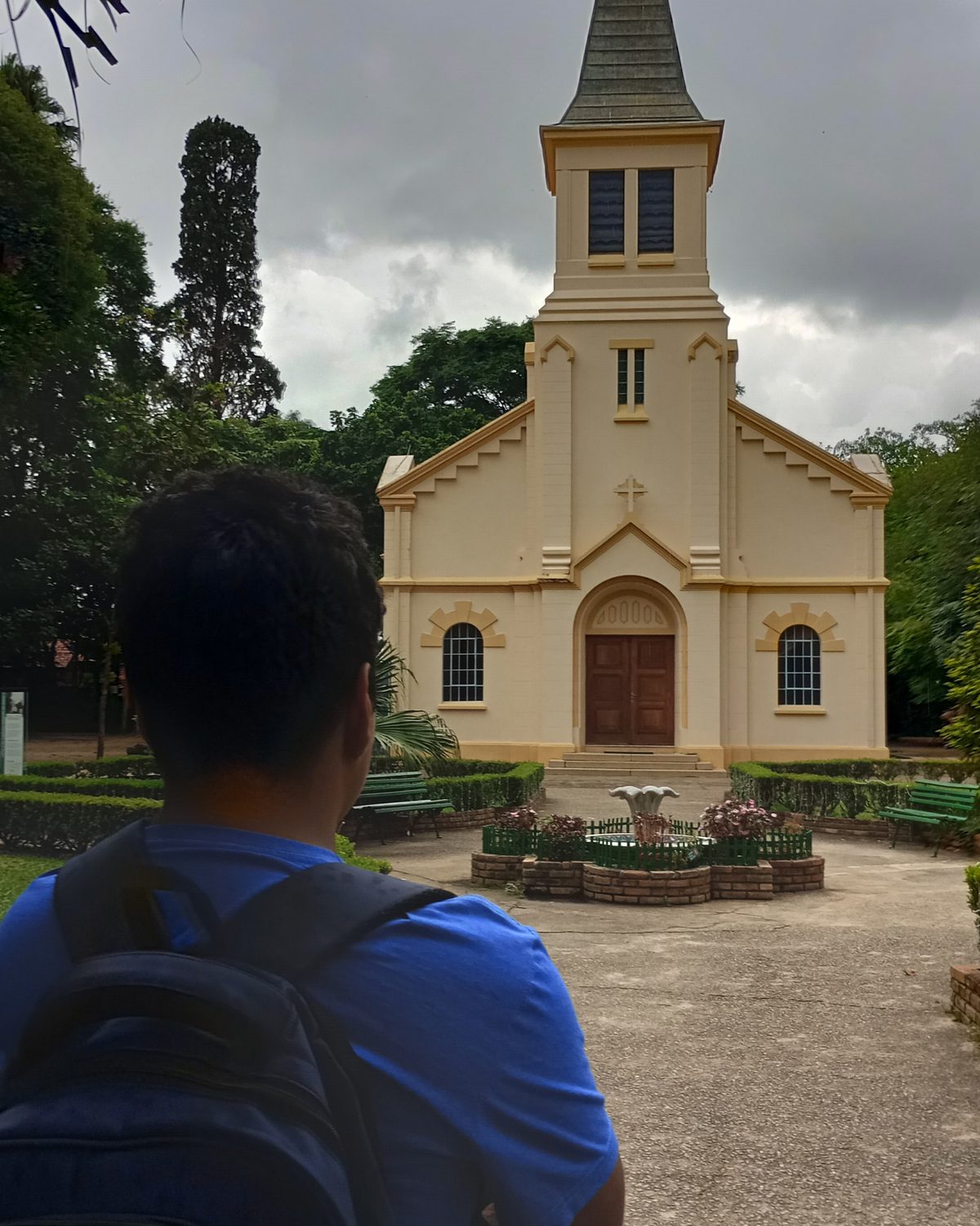 Rapaz de mochila olhando a capela do Parque Vicentina Aranha, em São José dos Campos.