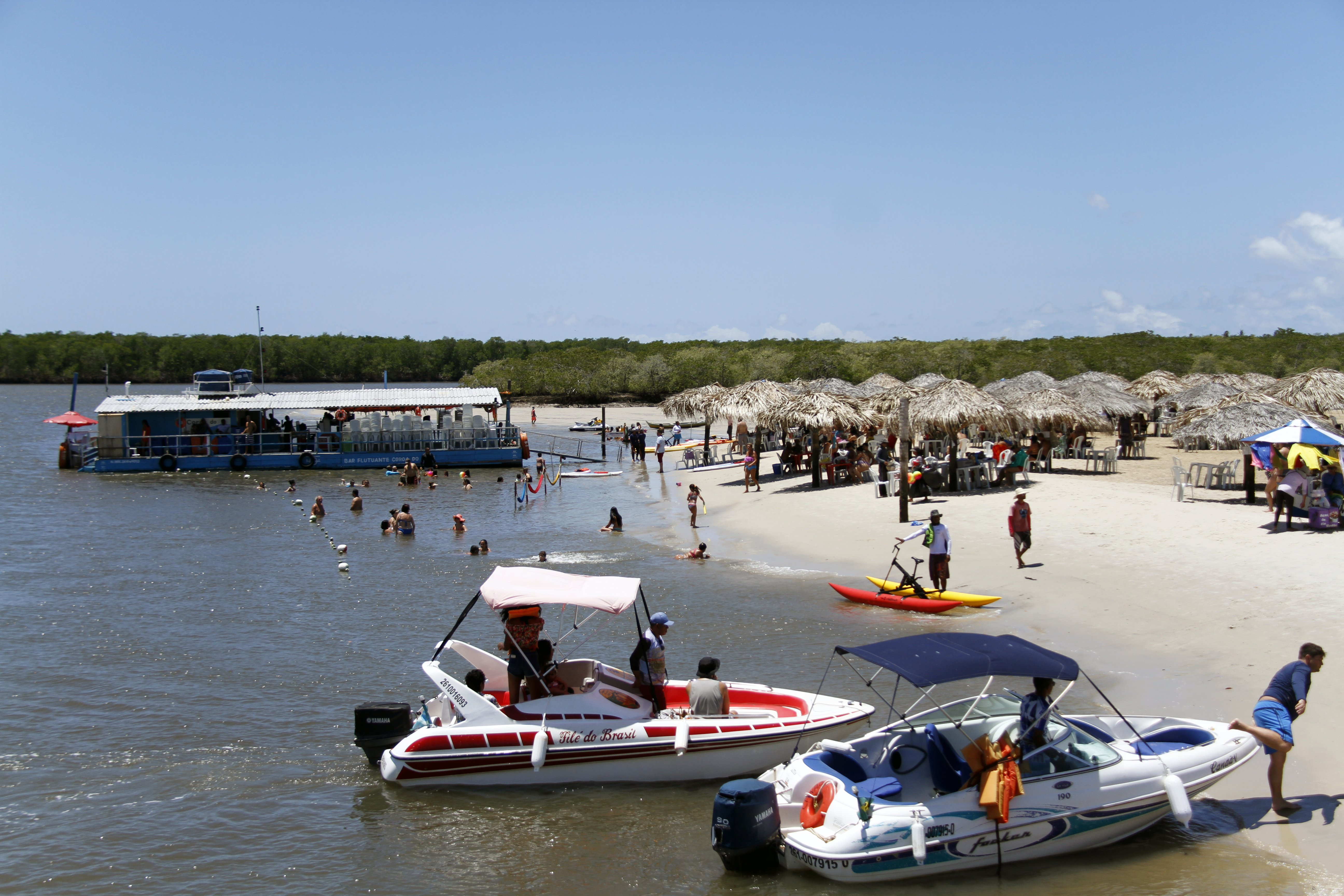 Bar flutuante e barcos ancorados na Croa do Goré, banco de areia cercado de manguezal, com pessoas na água