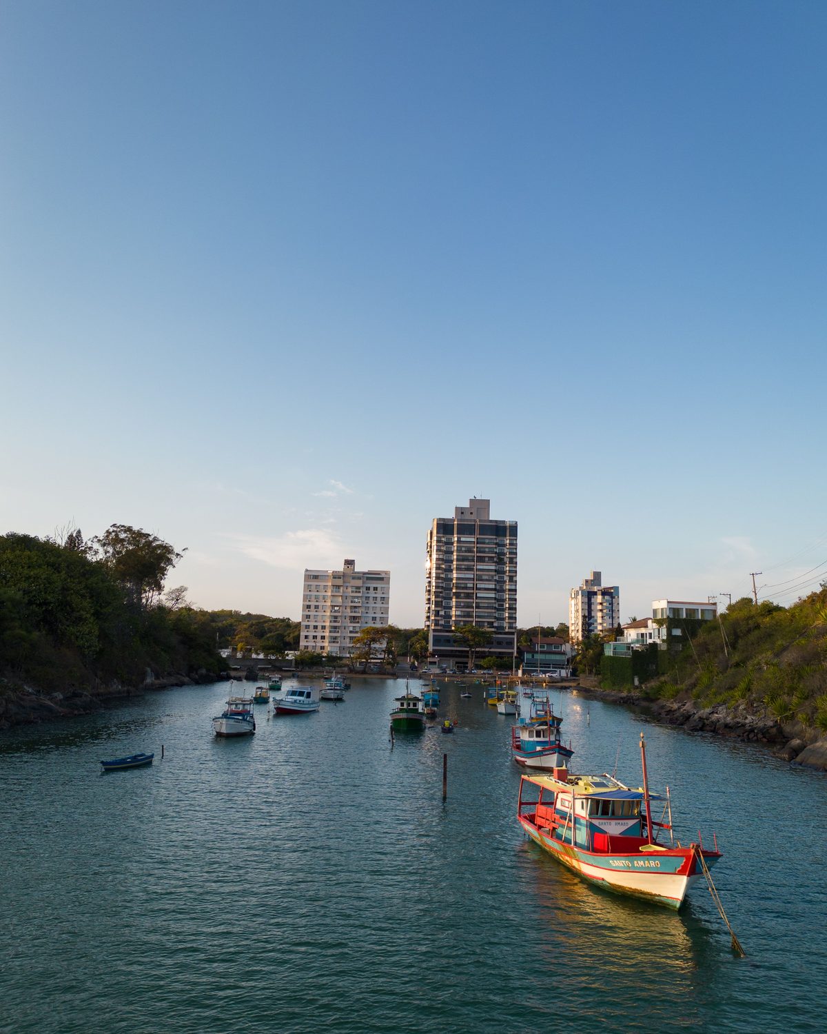 Barcos de pesca coloridos ancorados no canal da Praia da Costa ao fim da tarde.